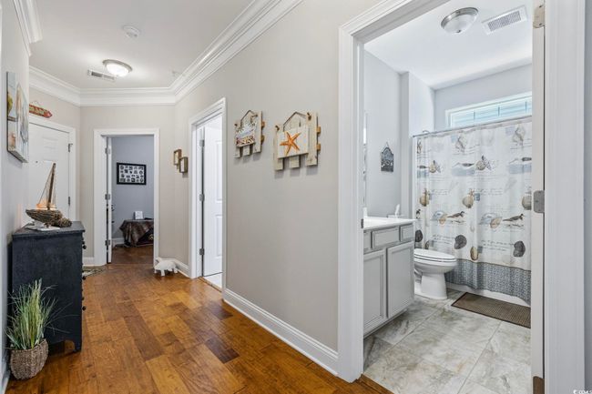 Hall with crown molding, baseboards, and light wood-style flooring | Image 24