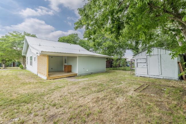 Back of property with metal roof, a storage unit, an outdoor structure, and a lawn | Image 30