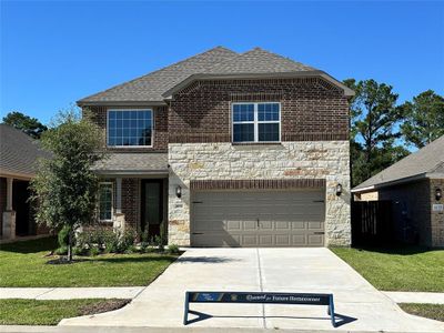 The Sequoia is a beautiful two-story home with a unique two-tone brick and stone design. The home has front yard landscaping and upgraded light fixtures on either side of the garage, with large windows for added curb appeal. | Image 1