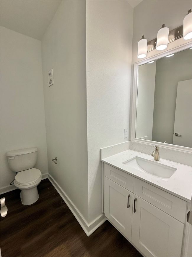Bathroom featuring wood finished floors, toilet, vanity, and baseboards | Image 6