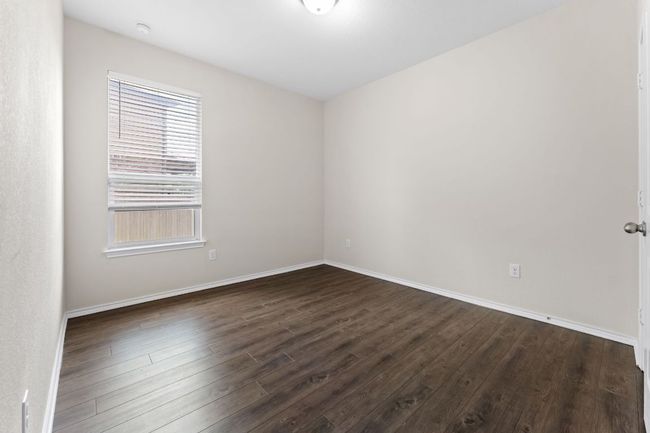 Guest 3 room with dark wood-style floors and baseboards | Image 24