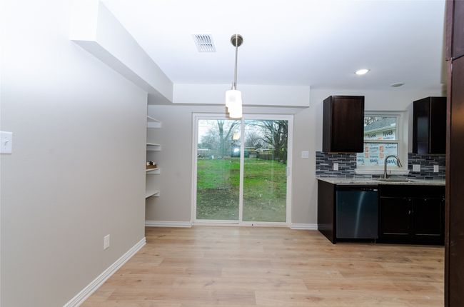 Dining with light wood finished floors. | Image 7
