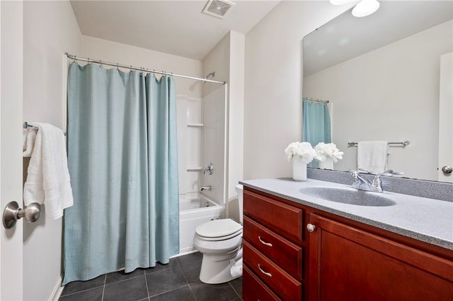 The full bath includes a large vanity and tiled floors. | Image 21