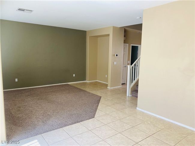 Unfurnished room featuring light tile patterned floors, visible vents, stairway, and baseboards | Image 10
