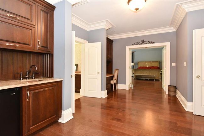 Bar area with coffered ceiling, dark wood finished floors, backsplash, and beamed ceiling | Image 12