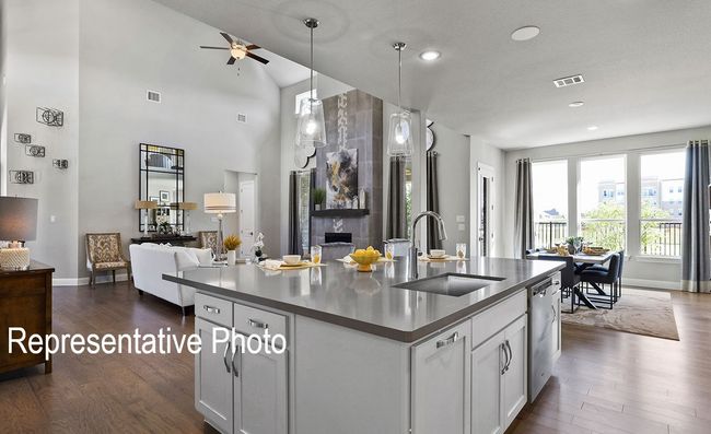 Kitchen with dark countertops, dark wood-style floors, open floor plan, a center island with sink, and recessed lighting | Image 4