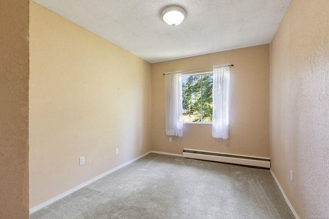 Empty room with baseboard heating, carpet floors, and baseboards | Image 17