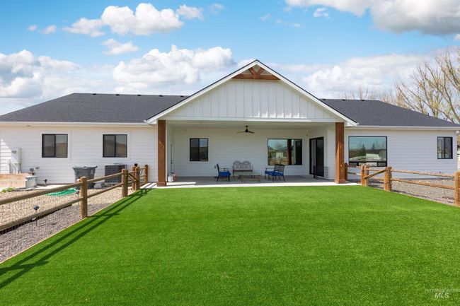 Back of house with ceiling fan, board and batten siding, a patio, and a fenced backyard | Image 4