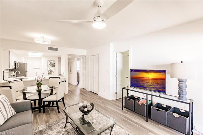 Living room featuring baseboards, a ceiling fan, light wood-style floors, and visible vents | Image 7