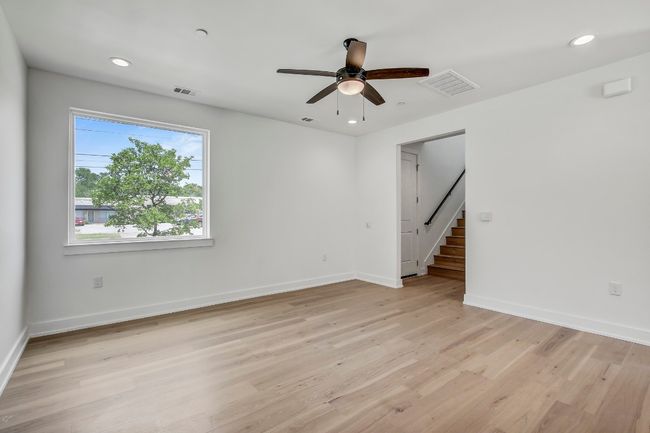 Spare room featuring a ceiling fan, baseboards, light wood-type flooring, stairway, and recessed lighting | Image 12