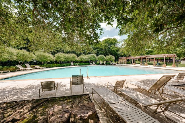 Community pool featuring view of wooded area and a patio area | Image 29