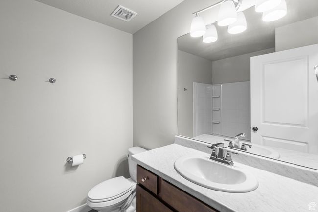 Bathroom with toilet, vanity, baseboards, visible vents, and a shower | Image 23