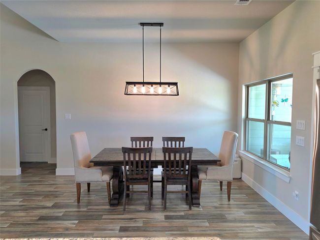Dining area featuring arched walkways and wood finished floors | Image 13