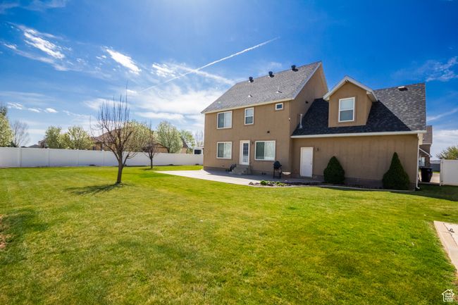 Back of house featuring a patio, roof with shingles, a yard, and fence | Image 35