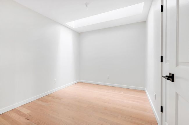 Spare room with a skylight and hardwood / wood-style flooring | Image 37