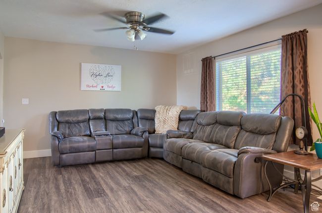 Living area featuring dark wood finished floors, a ceiling fan, and baseboards | Image 37