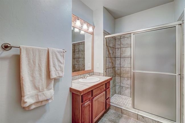 Bathroom featuring vanity, tile patterned floors, and a stall shower | Image 33
