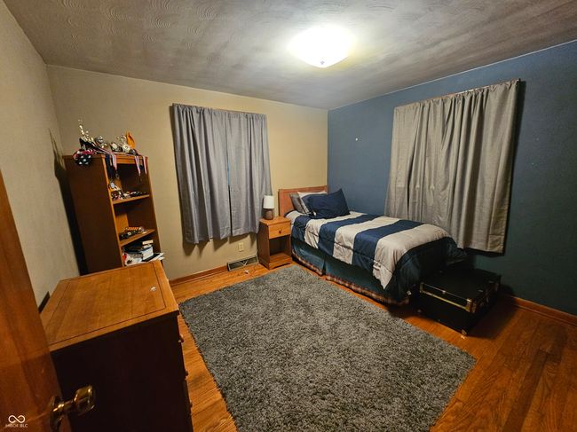 bedroom with wood finished floors and baseboards | Image 19