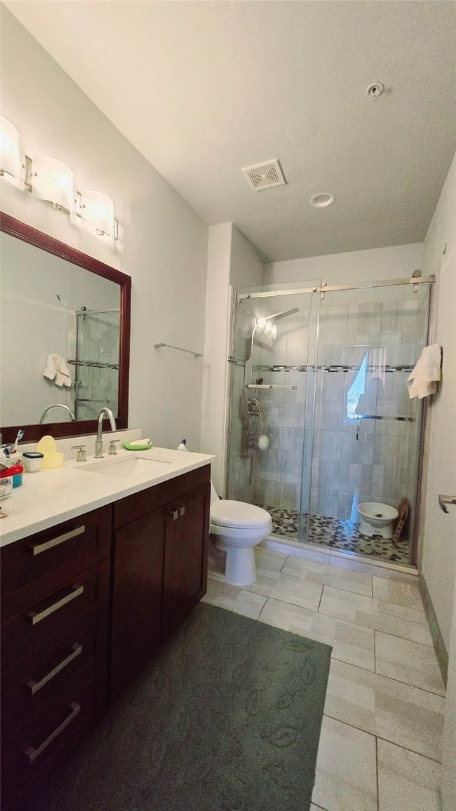 Full bath featuring vanity, a shower stall, and tile patterned flooring | Image 10