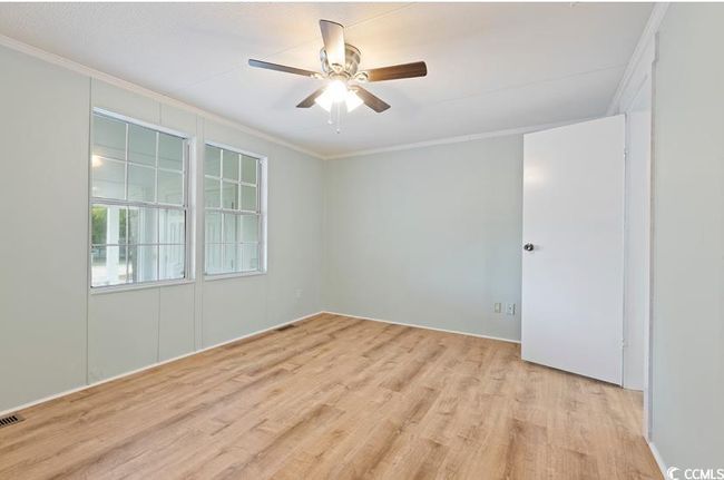 Spare room with ornamental molding, light wood-style floors, and ceiling fan | Image 20