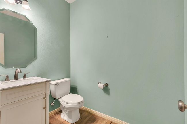 Bathroom featuring baseboards, toilet, vanity, and wood finished floors | Image 27