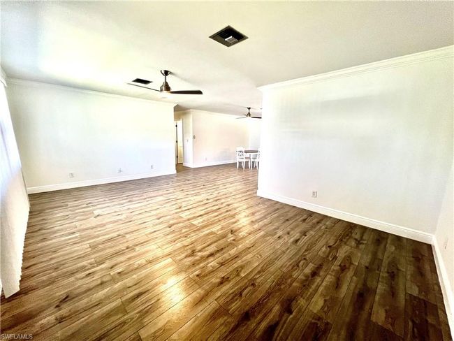 Living room featuring crown molding, LUXURY VINYL PLANK FLOORS. | Image 15