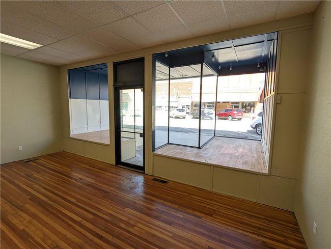 Empty room with a paneled ceiling and hardwood / wood-style flooring | Image 20