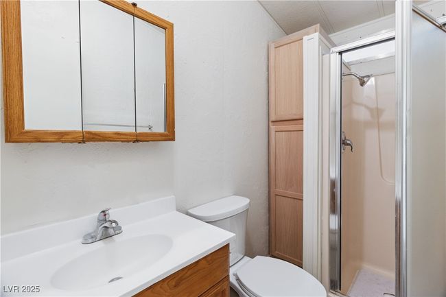 Full bathroom with toilet, a shower stall, and vanity | Image 17