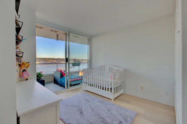 Bedroom with wood finished floors and a water view | Image 18