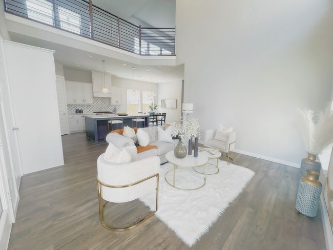 Living room with dark wood finished floors, a towering ceiling, and baseboards | Image 10