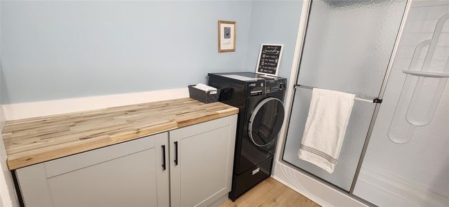 Laundry area featuring light wood-style floors, washer / dryer, and laundry area | Image 20