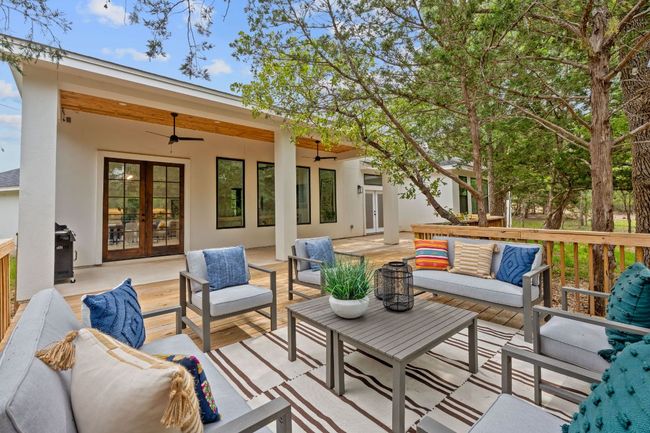 Wooden deck with french doors, ceiling fan, and outdoor lounge area | Image 34