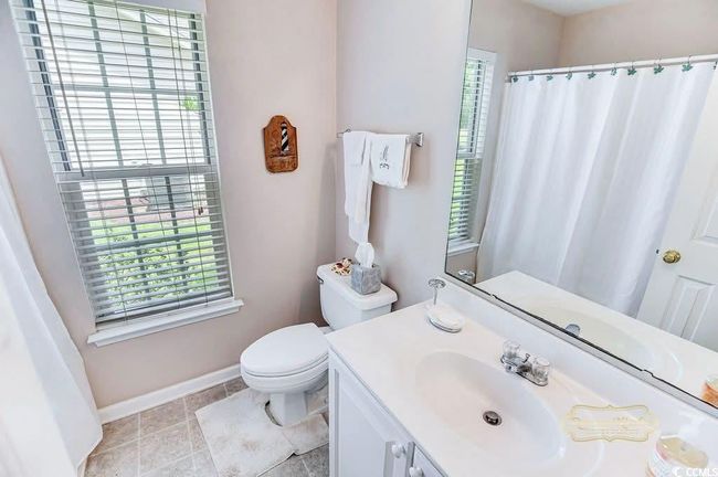 Full bathroom with plenty of natural light, vanity, tile patterned floors, and curtained shower | Image 24