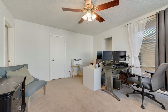 Carpeted home office with ceiling fan and a textured ceiling | Image 15
