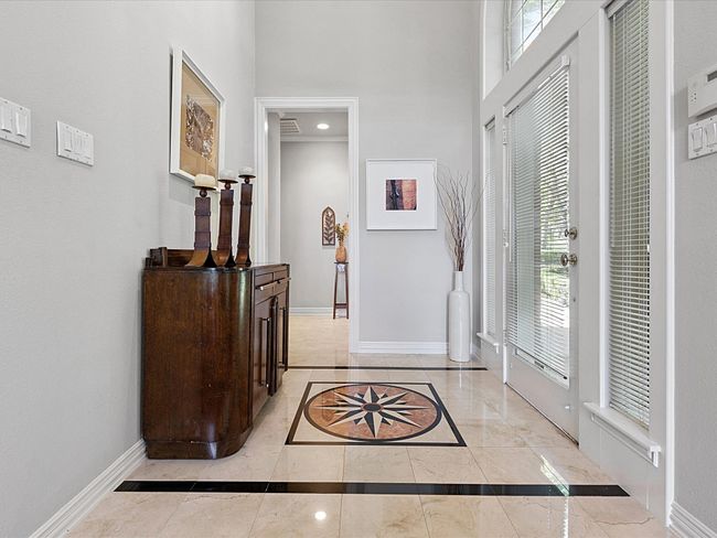 Entryway featuring inlaid floor details, a towering ceiling, and natural stone finish flooring | Image 5