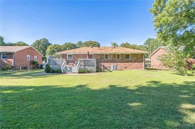 Rear view of property featuring a wooden deck and a lawn | Image 2