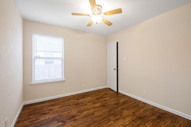 Empty room with plenty of natural light, wood finished floors, and a ceiling fan | Image 15