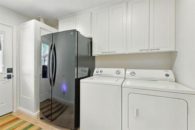The laundry room accommodates a full size washer and dryer with room for a second refrigerator and lots of cabinet/storage space. | Image 14
