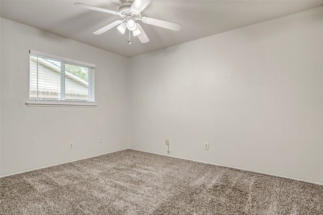 Empty room with carpet flooring, ceiling fan, and baseboards | Image 27