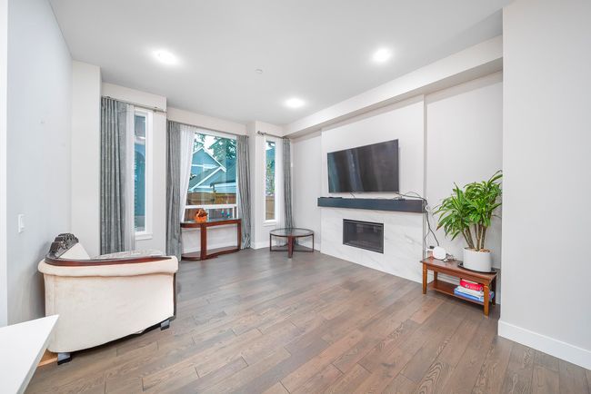 Living area featuring a high end fireplace, wood finished floors, recessed lighting, and baseboards | Image 7