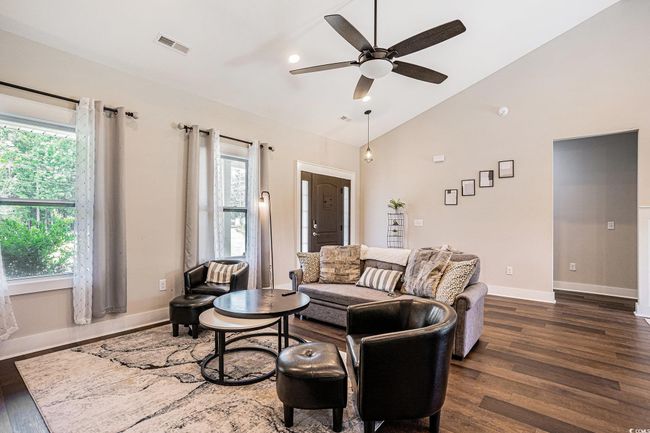 Living room featuring dark wood-type flooring, ceiling fan, and high vaulted ceiling | Image 5