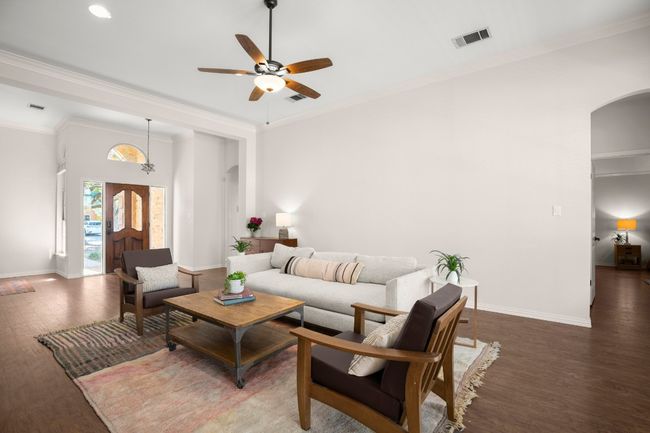 Living area featuring arched walkways, crown molding, ceiling fan, and wood finished floors | Image 11