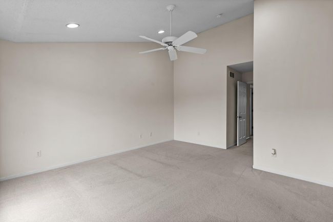 The vaulted ceiling has recessed lighting and a ceiling fan. | Image 23