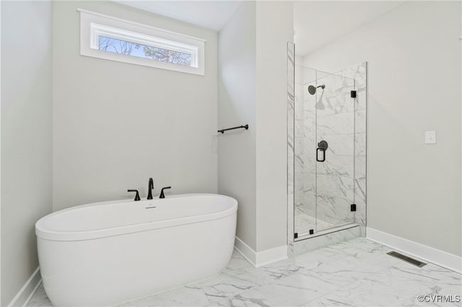 Photo represents the plan, not the actual home. Design selections may vary. The first-floor primary suite includes a walk-in closet and an ensuite bath featuring a double vanity, a tiled walk-in shower, a water closet, and a linen closet. | Image 7