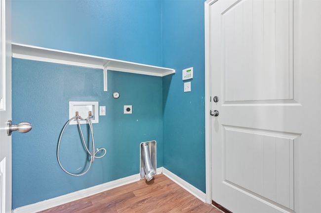 Laundry area with wood finished floors, hookup for a washing machine, and hookup for an electric dryer | Image 4