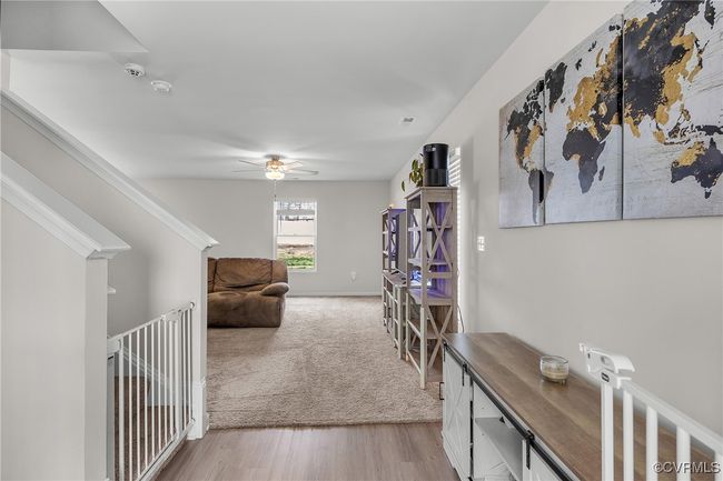 Hallway with light carpet and light wood-style flooring | Image 4