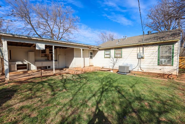 Rear view of property with central air condition unit, a patio area, and a yard | Image 30