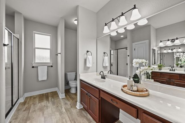 Full bathroom featuring a shower stall, wood-like finished floors, and vanity | Image 20