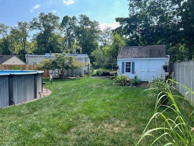 View of yard with a storage shed, a fenced backyard, and pool | Image 30