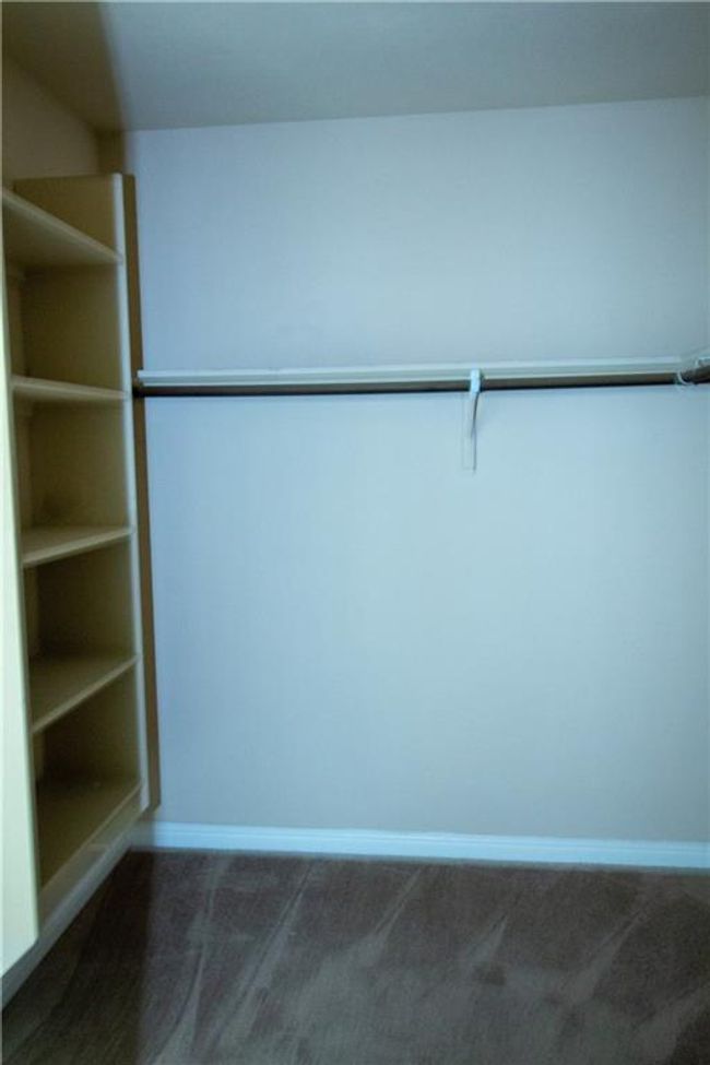 Spacious closet featuring dark colored carpet | Image 10